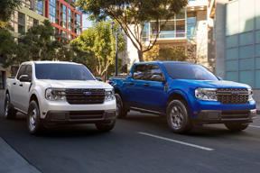 A white truck and a blue truck on a street
